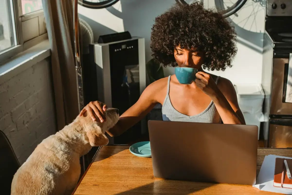 02-Pet-Sitter-vs-Pet-Kennel-pet-sitter-with-a-cat-at-home-drinking-coffee