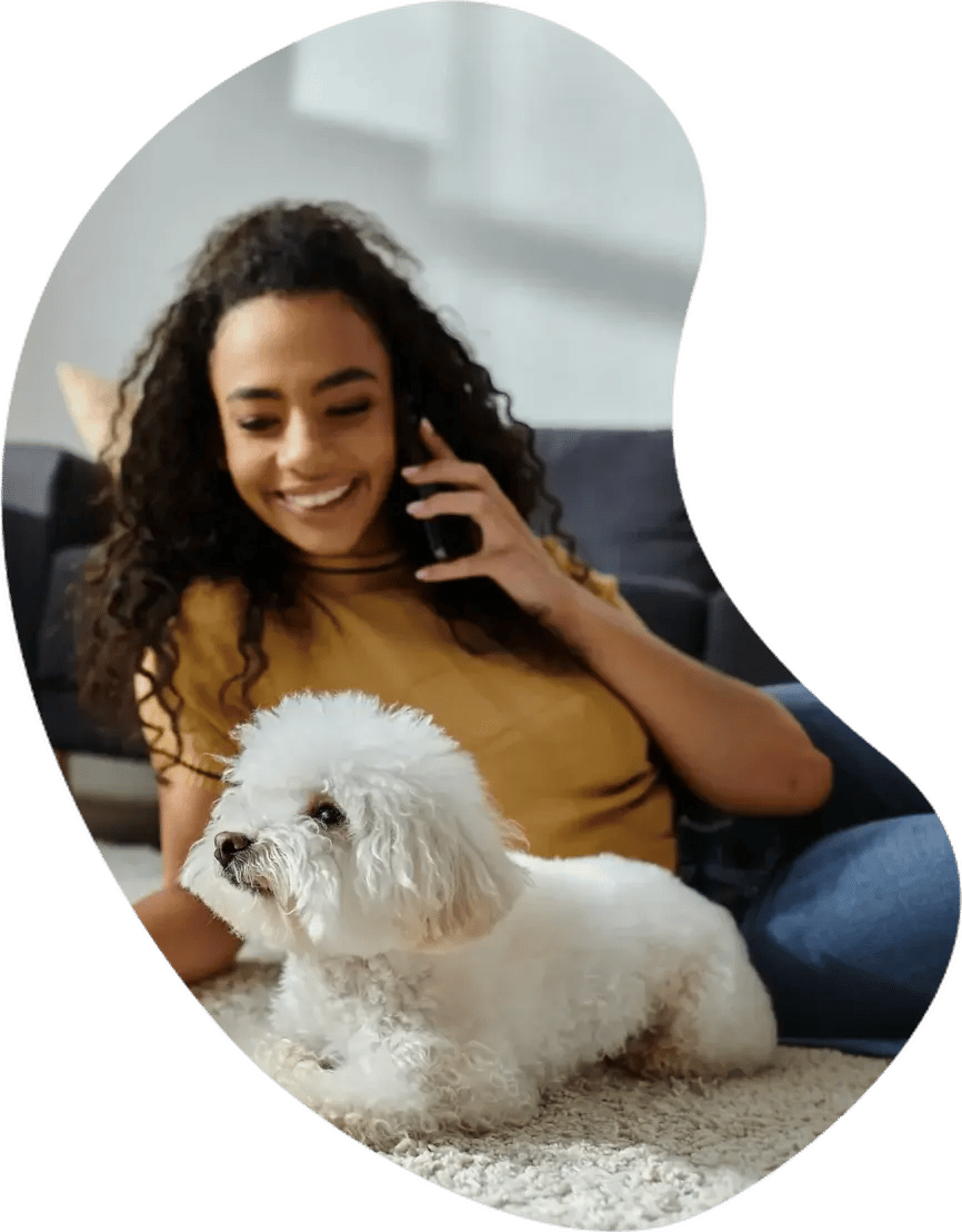 Pet parent at home with her dog, booking care on her phone